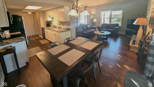 dining area featuring dark hardwood / wood-style flooring, a chandelier, and sink