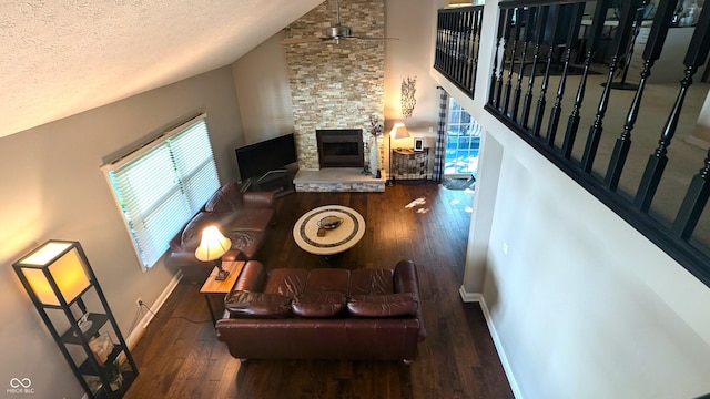 living room featuring a stone fireplace, dark wood-type flooring, and vaulted ceiling