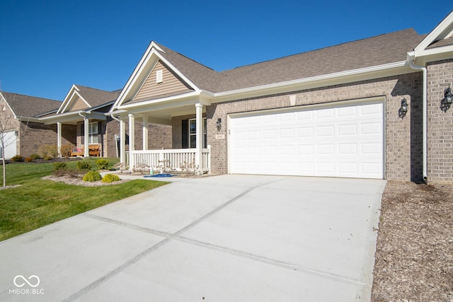 view of front of property with a front yard, a porch, and a garage