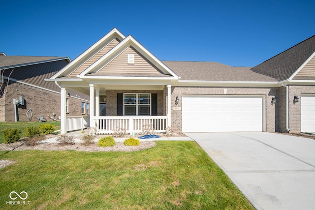 craftsman-style house with covered porch, a front yard, and a garage