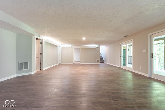 unfurnished room with a textured ceiling and dark wood-type flooring