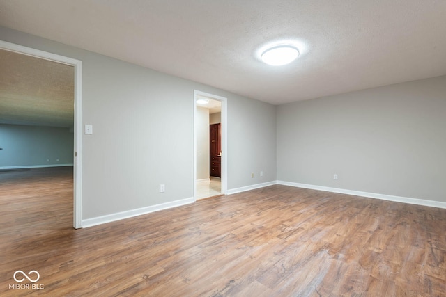 spare room with wood-type flooring and a textured ceiling