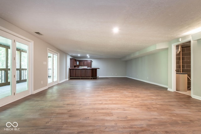 unfurnished living room with a textured ceiling and hardwood / wood-style flooring