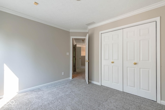 unfurnished bedroom featuring a closet, carpet floors, ornamental molding, and a textured ceiling