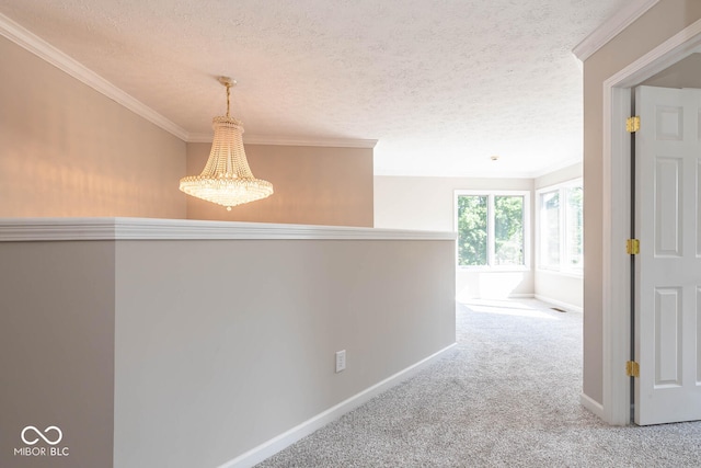 corridor featuring a textured ceiling, crown molding, an inviting chandelier, and carpet