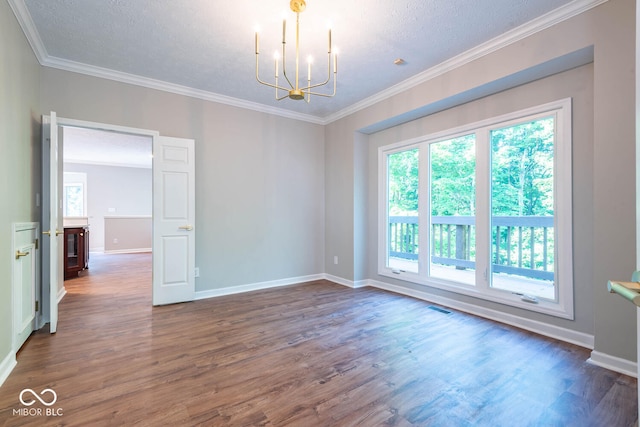 spare room featuring dark hardwood / wood-style flooring, a textured ceiling, a chandelier, and crown molding