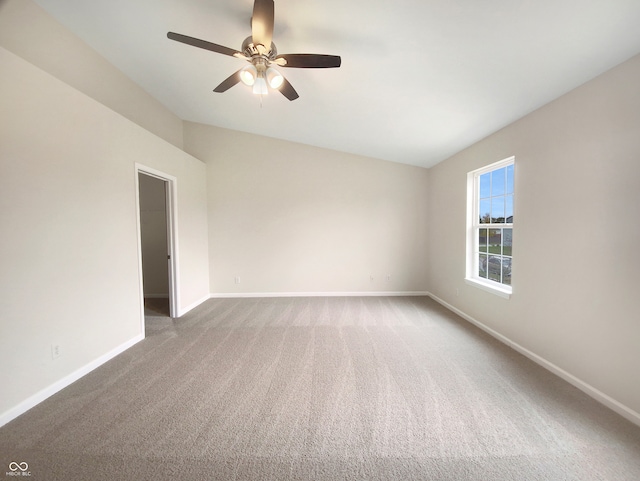 spare room with ceiling fan, carpet flooring, and vaulted ceiling