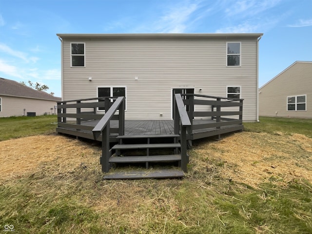 rear view of property featuring a wooden deck and a yard