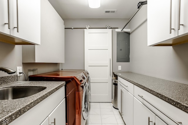 kitchen with electric panel, sink, white cabinets, and washer and dryer