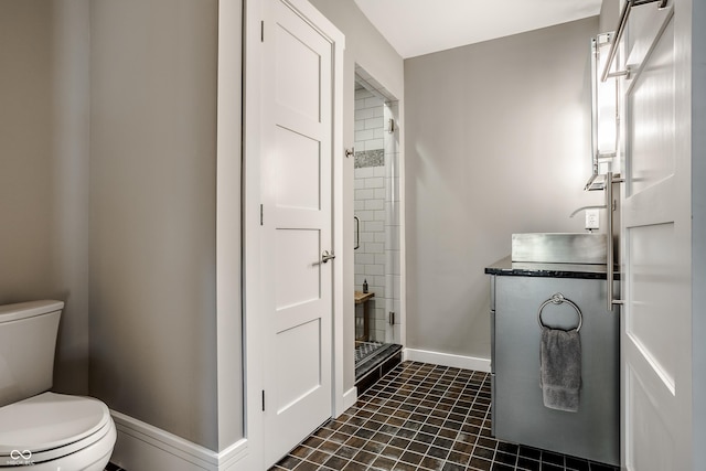 bathroom featuring a tile shower and toilet