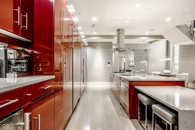 kitchen featuring island range hood, a spacious island, and light stone counters