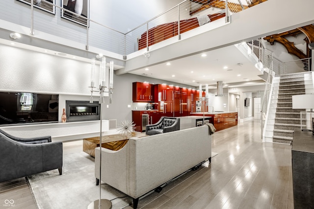 living room featuring a towering ceiling and light hardwood / wood-style floors