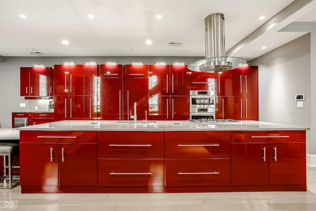 kitchen featuring light stone countertops, sink, stainless steel appliances, island exhaust hood, and a kitchen island