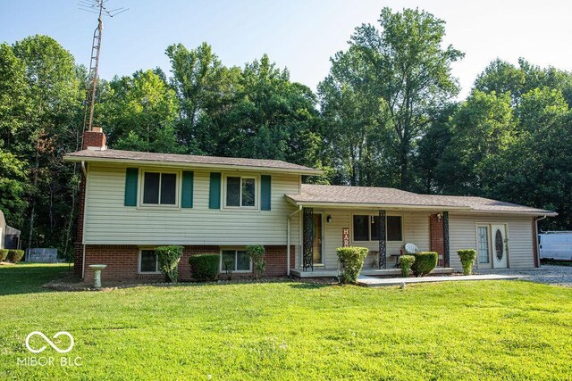 tri-level home with covered porch and a front yard