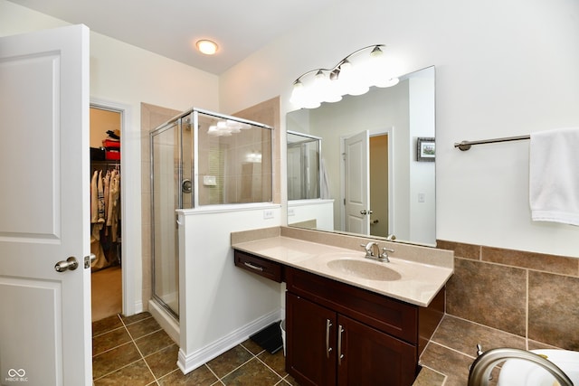 bathroom with walk in shower, vanity, and tile patterned flooring