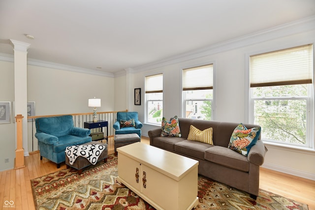 living room with light wood-type flooring, ornamental molding, and decorative columns