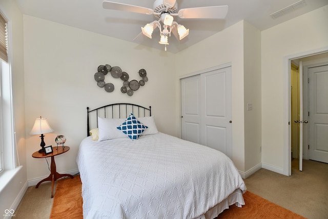 carpeted bedroom featuring ceiling fan and a closet