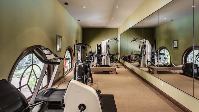 exercise room with carpet floors and a high ceiling