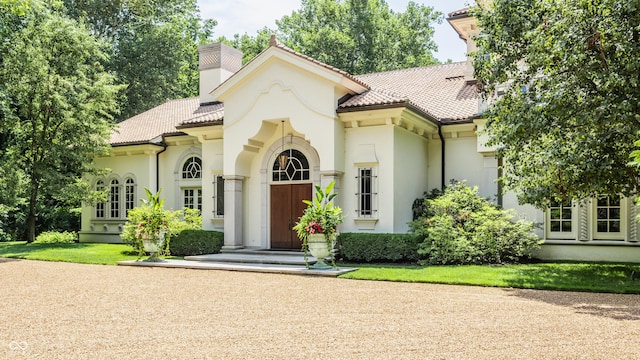 841 Alverna Dr, Indianapolis, IN 46260 - mediterranean / spanish house with stucco siding, a chimney, and a tile roof