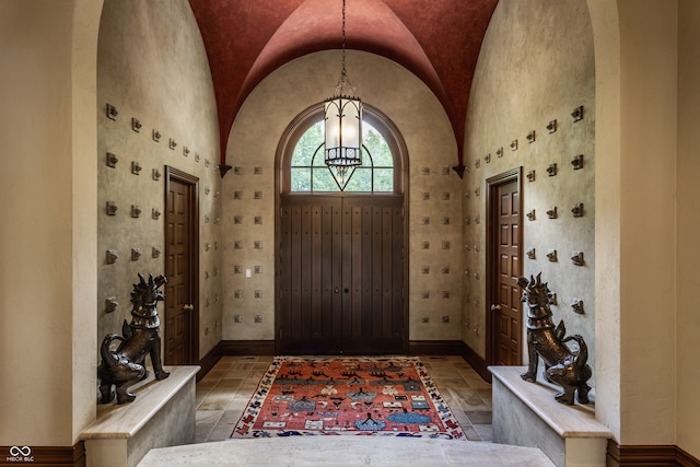 foyer with an inviting chandelier and vaulted ceiling