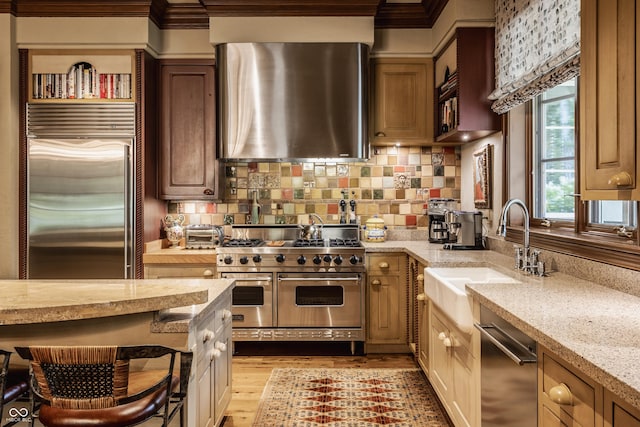 841 Alverna Dr, Indianapolis, IN 46260 - kitchen featuring high end appliances, range hood, tasteful backsplash, light stone countertops, and light wood-style flooring