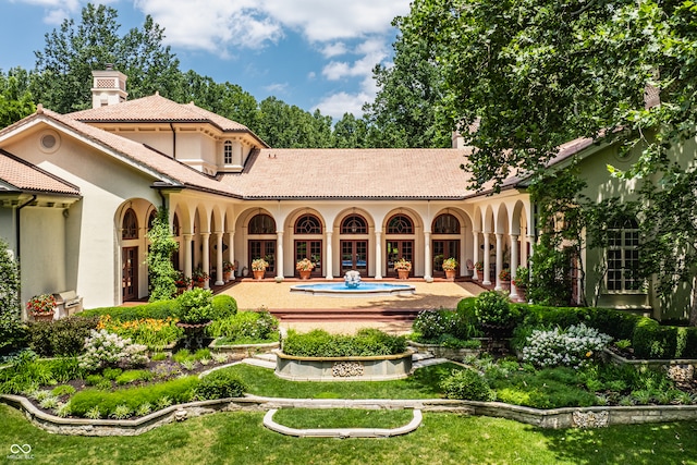 rear view of house with a lawn and a patio