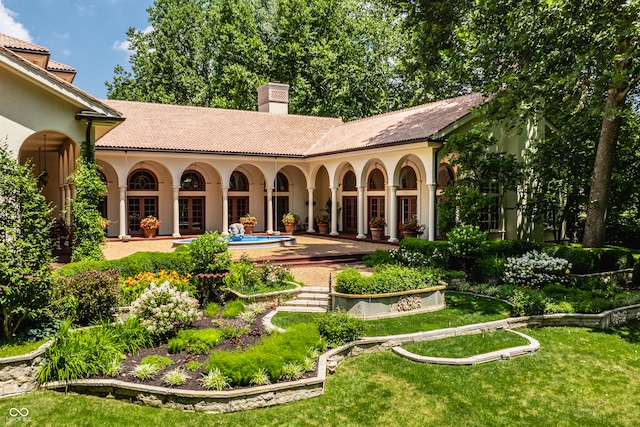 back of house with a lawn and french doors