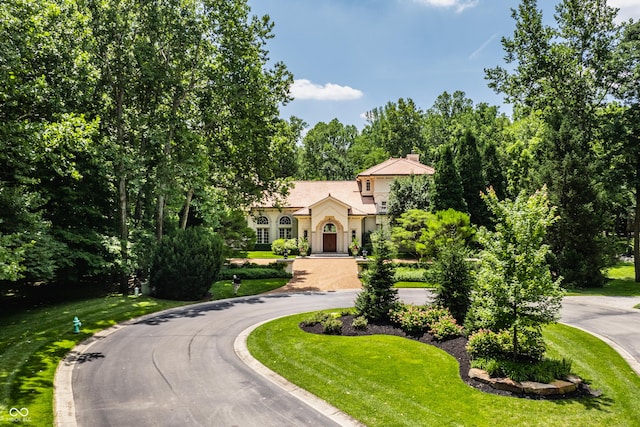 841 Alverna Dr, Indianapolis, IN 46260 - view of front of house featuring curved driveway, a chimney, a front lawn, and stucco siding