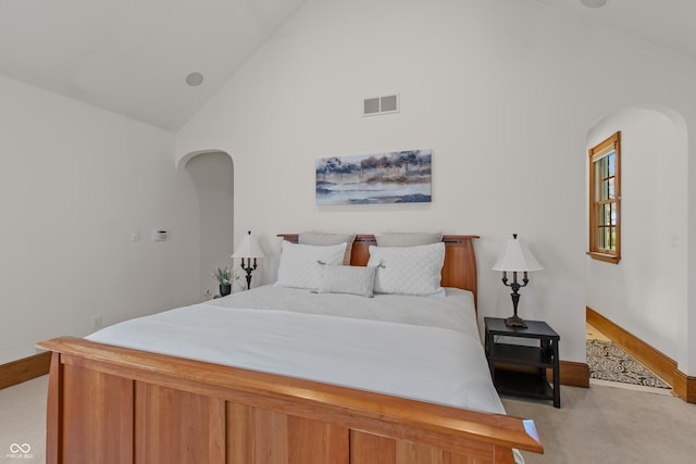 bedroom with light carpet and high vaulted ceiling