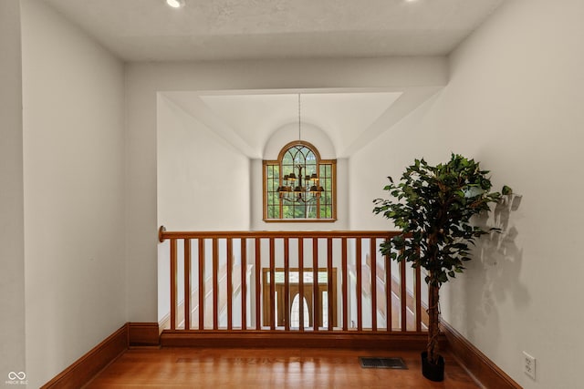 staircase featuring a notable chandelier and hardwood / wood-style flooring