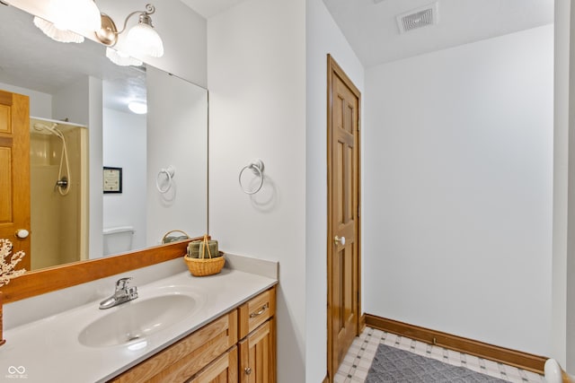 bathroom with a shower, vanity, and toilet