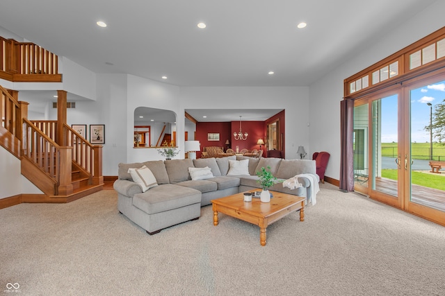 living room featuring light carpet and a chandelier