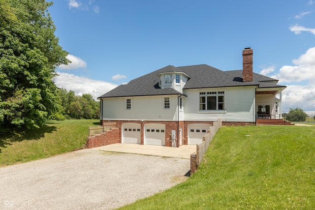 rear view of house with a lawn and a garage