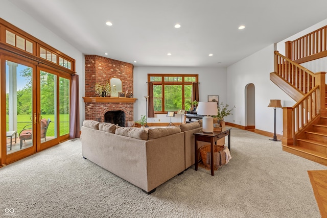 carpeted living room with french doors and a brick fireplace