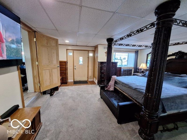 carpeted bedroom featuring a drop ceiling