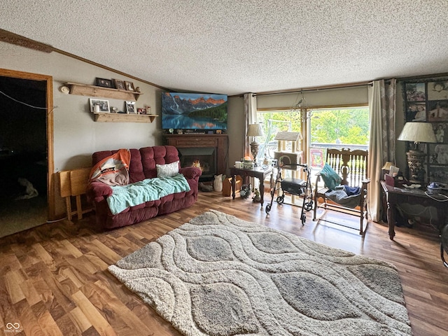 living room with vaulted ceiling, wood-type flooring, a textured ceiling, and crown molding