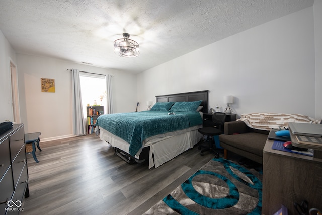 bedroom with a textured ceiling and wood-type flooring