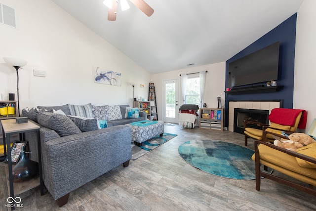 living room with hardwood / wood-style floors, a fireplace, high vaulted ceiling, and ceiling fan