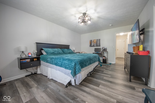 bedroom featuring a textured ceiling and wood-type flooring