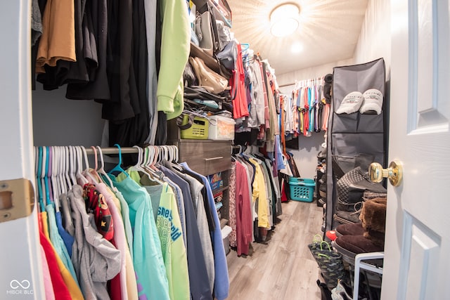 walk in closet with light hardwood / wood-style flooring