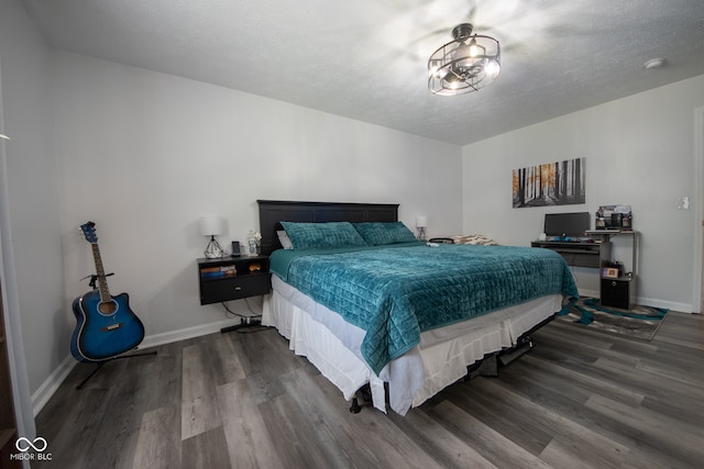 bedroom with hardwood / wood-style floors and a textured ceiling