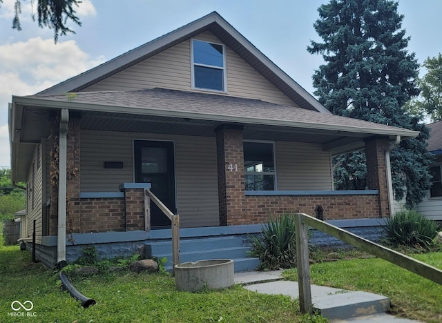 bungalow-style home with a front lawn and covered porch