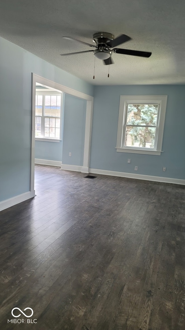 empty room featuring ceiling fan, hardwood / wood-style floors, and a healthy amount of sunlight