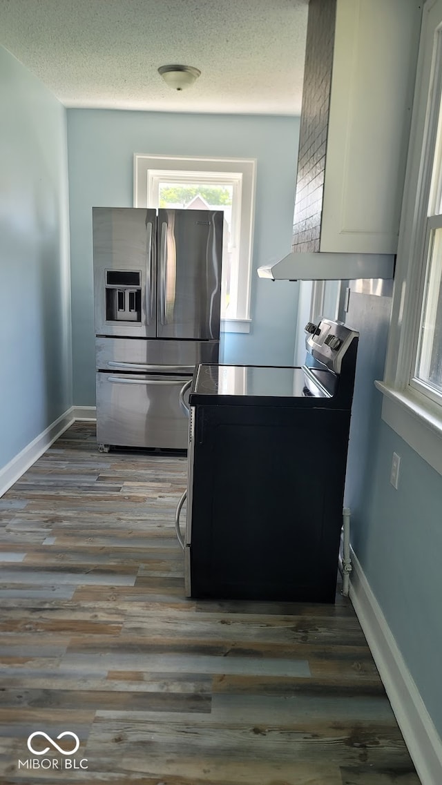 kitchen with hardwood / wood-style flooring, stainless steel fridge with ice dispenser, a textured ceiling, and range with electric stovetop