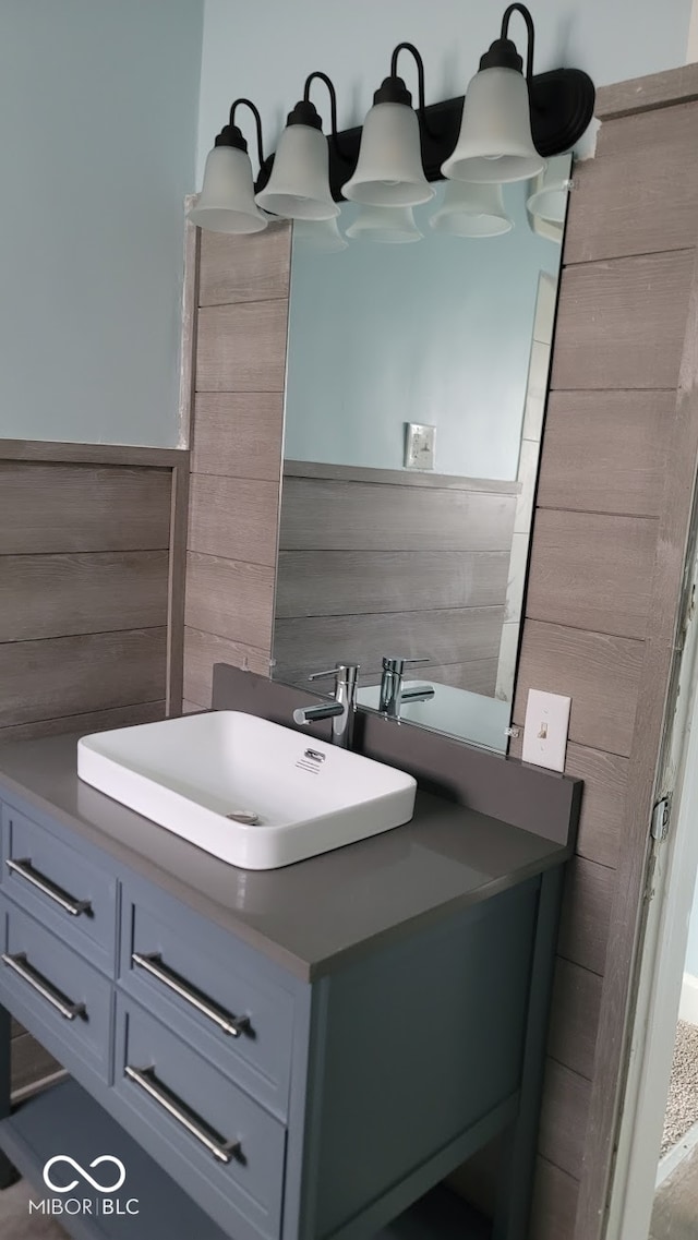 bathroom with wood walls and vanity