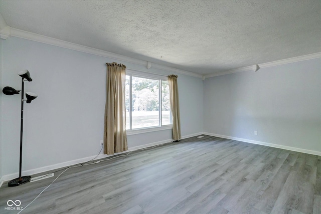 empty room with a textured ceiling, light hardwood / wood-style flooring, and ornamental molding