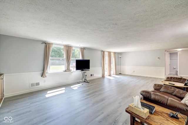 living room with a textured ceiling and hardwood / wood-style flooring