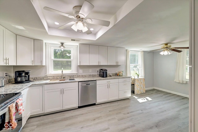 kitchen with stainless steel appliances, a tray ceiling, sink, light hardwood / wood-style flooring, and white cabinetry