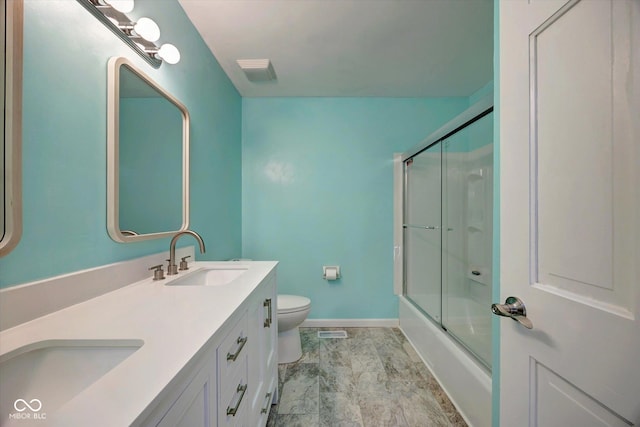 full bathroom with vanity, bath / shower combo with glass door, and toilet