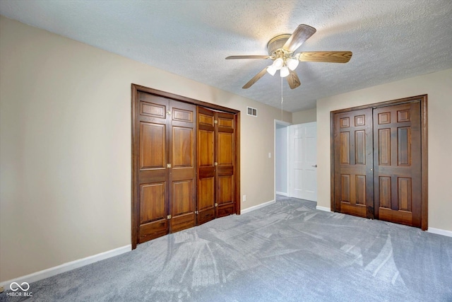 unfurnished bedroom featuring ceiling fan, carpet floors, and a textured ceiling